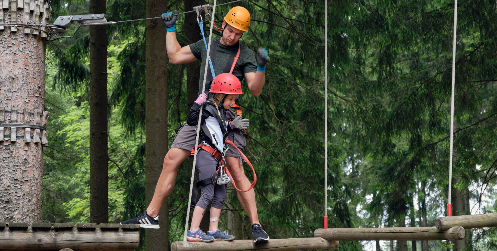Erwachsener und Kind beim klettern auf einem Balancierelement